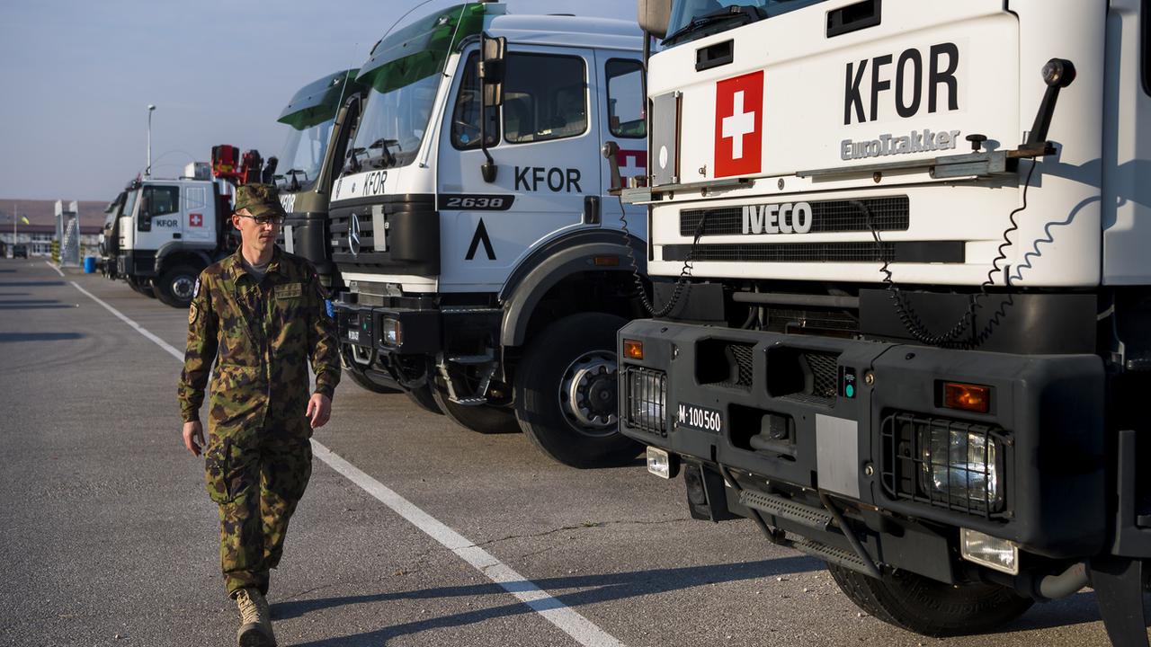 Le Capitaine Stephan Jedelhauser militaire suisse du contingent de la Swisscoy inspecte des camions. [Keystone - Jean-Christophe Bott]
