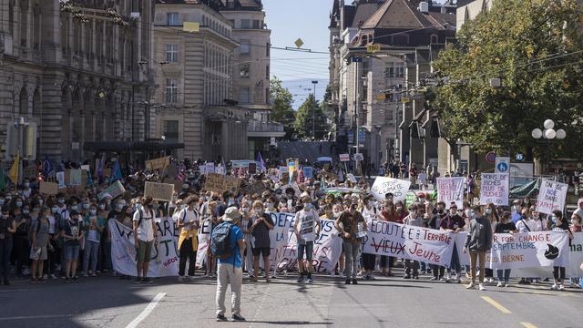 Des militants manifestent dans les rues de Lausanne lors d'une Grève du climat. [Keystone - Cyril Zingaro]