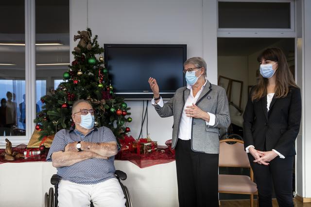 Les conseillères d'Etat vaudoises Béatrice Métraux (centre) et Rebecca Ruiz (droite) étaient présentes lors de la première vaccination du canton. [Keystone - Jean-Christophe Bott]