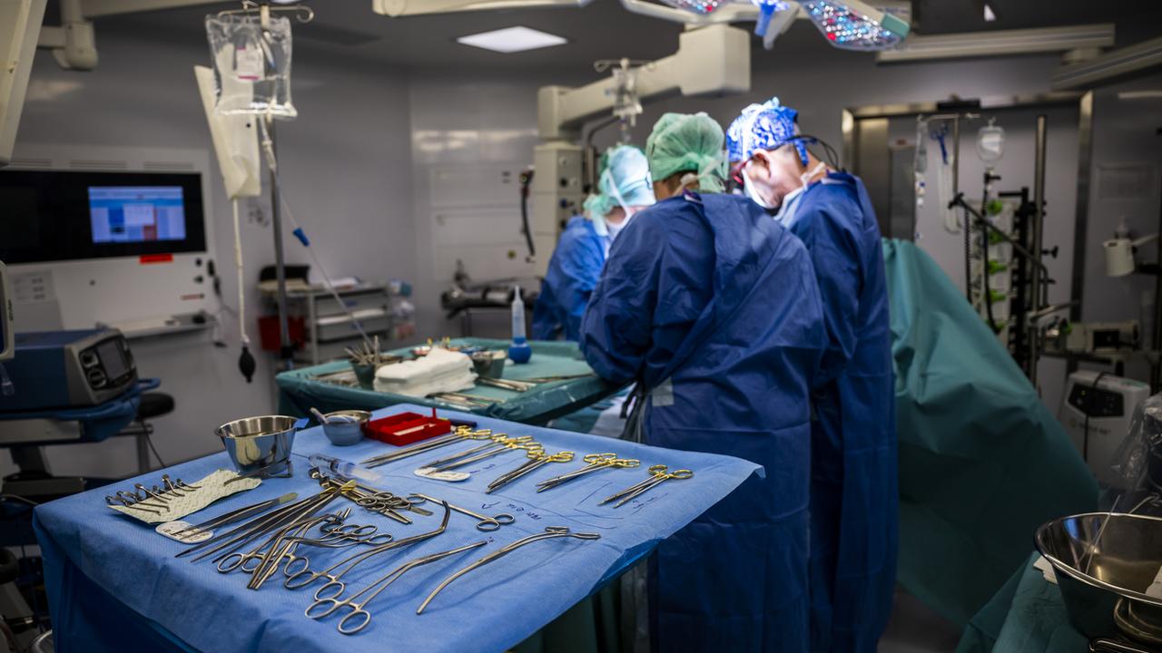 Le personnel d'un bloc opératoire procédant à une transplantation. [Keystone - Martial Trezzini]