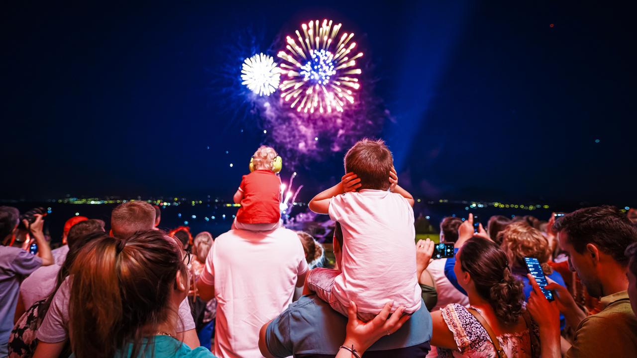 Un enfant se bouche les oreilles pendant le feu d'artifice du 1er août 2022 a Nyon. [Keystone - Valentin Flauraud]