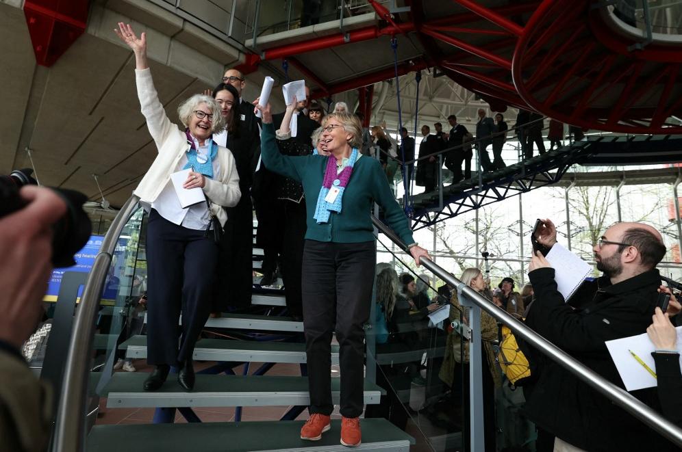 Des membres de l'association suisse des "Aînées pour la protection du climat" se réjouissent après l'arrêt rendu par la CEDH, le 9 avril 2024. [AFP - FREDERICK FLORIN]