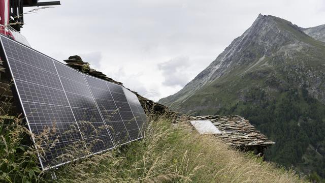 Un panneau solaire fournit de l'énergie aux petits chalets à proximité du village d'Arolla (VS), photographié le mardi 1er août 2023. [KEYSTONE - GAETAN BALLY]