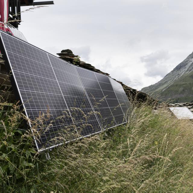 Un panneau solaire fournit de l'énergie aux petits chalets à proximité du village d'Arolla (VS), photographié le mardi 1er août 2023. [KEYSTONE - GAETAN BALLY]