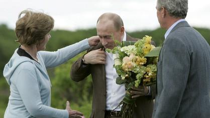 La First Lady Laura Bush, réajustant le col du président russe