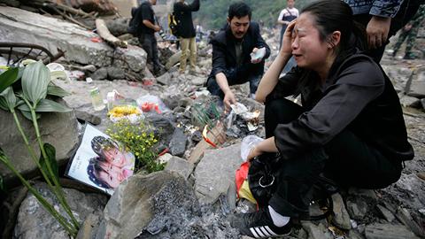 Une mère pleure la mort de sa fille sur les ruines du séisme.