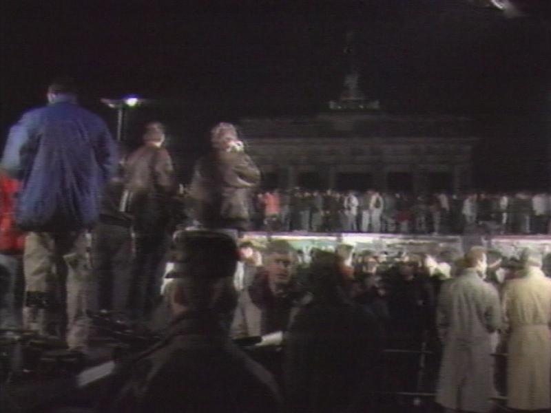 Foule de Berlinois sur le mur de la honte pour célébrer sa chute dans la nuit du 9 novembre 1989. [RTS]