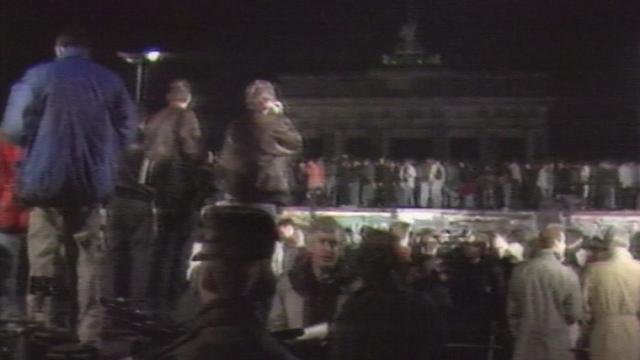 Foule de Berlinois sur le mur de la honte pour célébrer sa chute dans la nuit du 9 novembre 1989. [RTS]