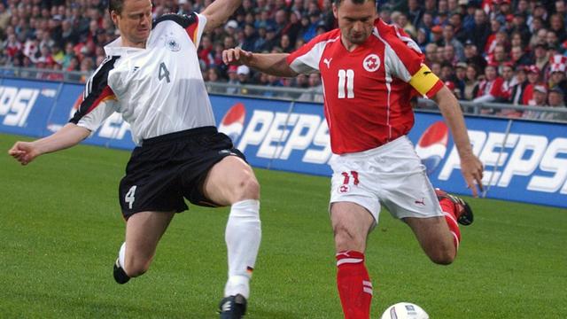 Lors de sa centième sélection en équipe nationale, l'attaquant Stéphane Chapuisat (à droite) tente d'éviter l'intervention du joueur allemand Christian Woerns dans un match amical de préparation pour l'Euro 2004. [Keystone - Walter Bieri]