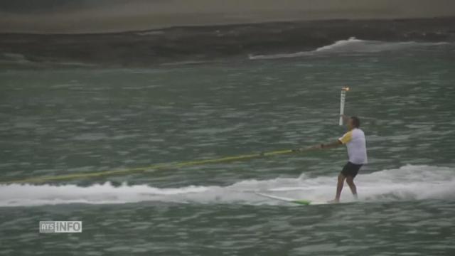 La flamme olympique fait un tour en surf à Rio