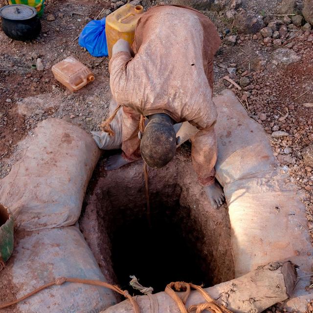 Chercheur d'or malien hissant des seaux de terre sur le site d'orpaillage de Kokoyo au sud-est du Mali [Tristan Miquel - Tristan Miquel]