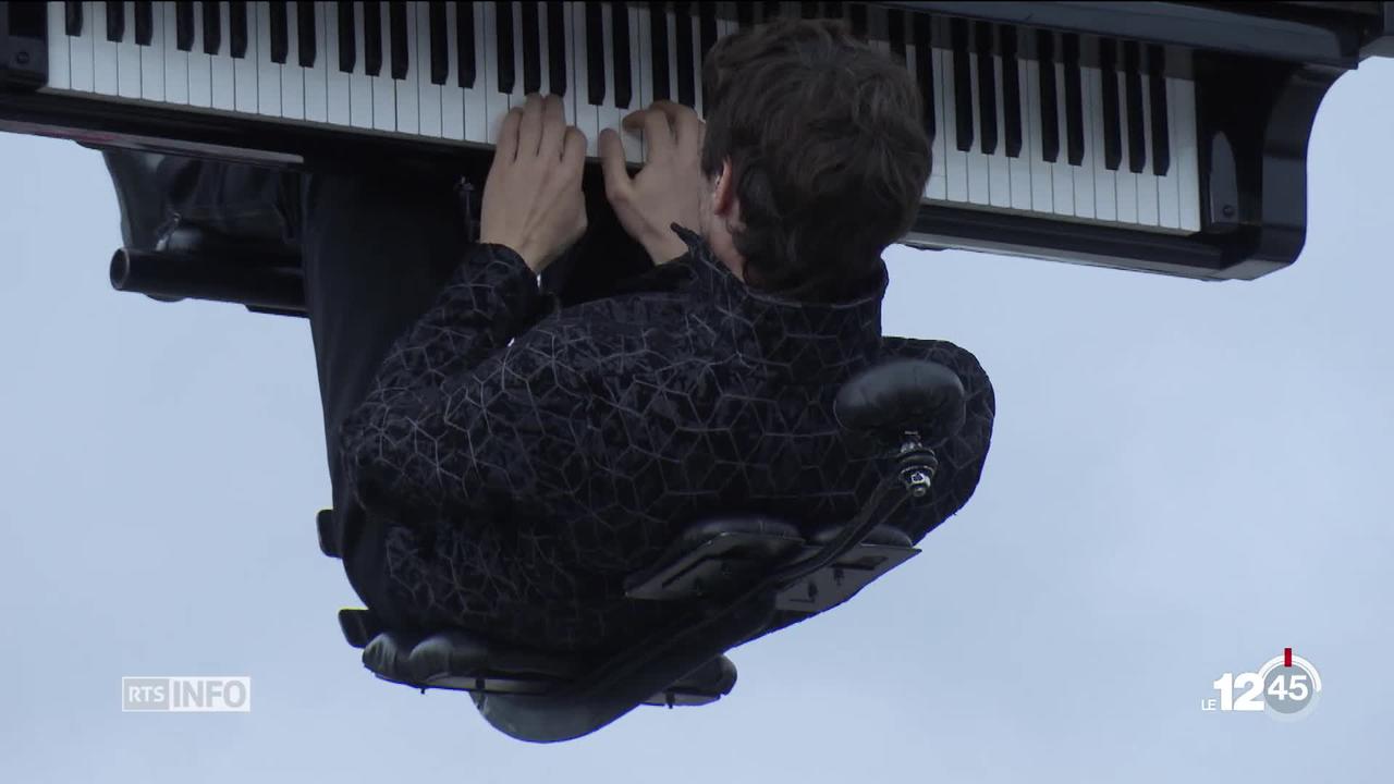 Le pianiste et compositeur Alain Roche joue accroché à une grue sur le parking de l'hôpital à Sion.
