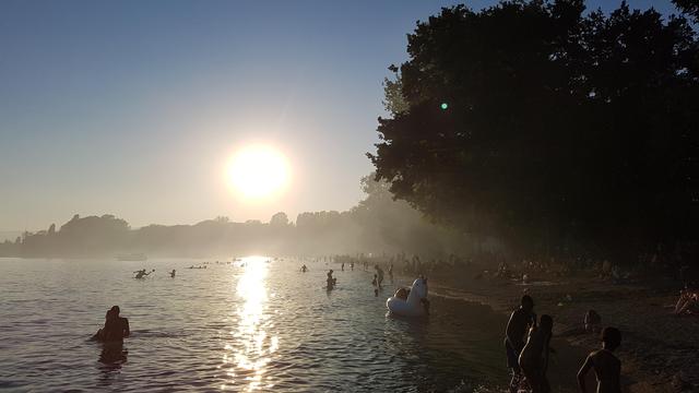 la plage de Vidy en fin de journée enfumée par les barbecues des nombreux estivants. [RTS - Rodolphe Bauchau]