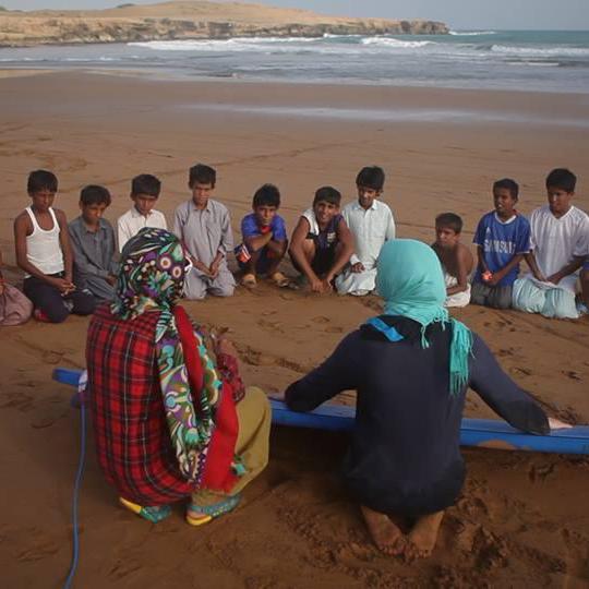 Enfants de Ramin à l’écoute des conseils des surfeuses. [DR - Marion Poizeau]