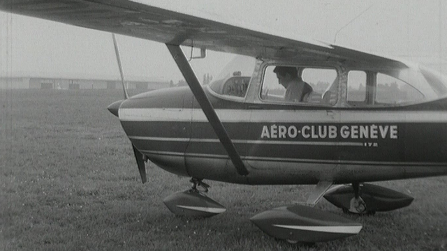 Gilbert Bécaud pilotant un avion en 1965. [RTS]