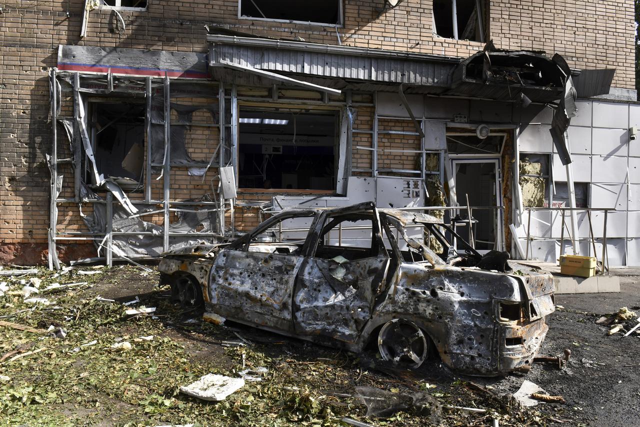 Une voiture calcinée devant un immeuble endommagé par un engin ukrainien à Koursk, en Russie, le 11 août 2024. [KEYSTONE - AP PHOTO]