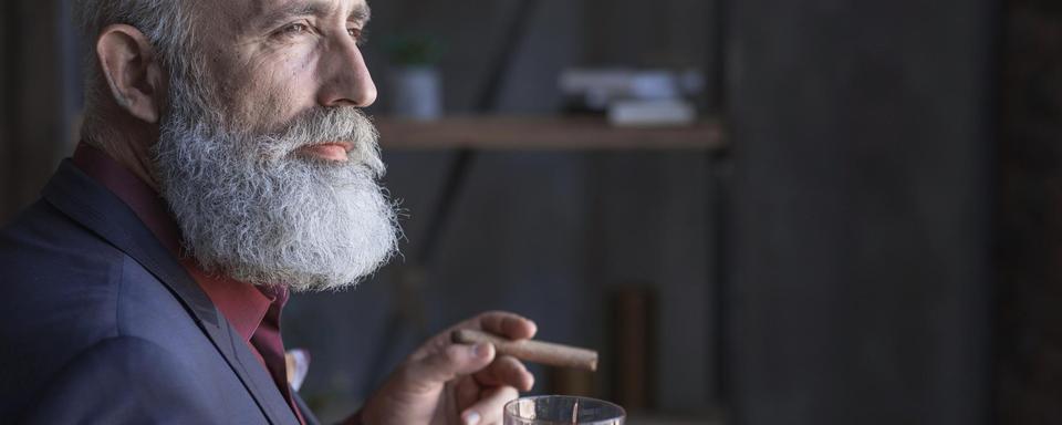 Homme mâture fumant le cigare et buvant de l'alcool. [Depositphotos - Iakovenko123]