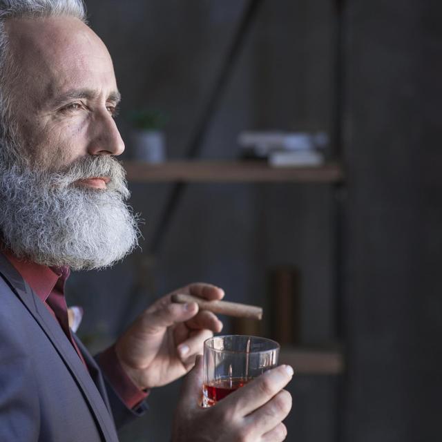 Homme mâture fumant le cigare et buvant de l'alcool. [Depositphotos - Iakovenko123]