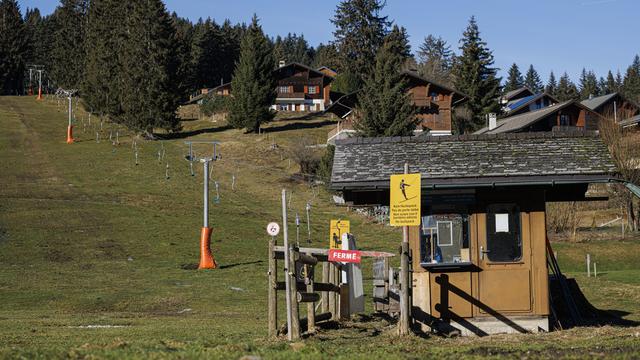 Un téléski fermé en raison du manque de neige est photographié sur le domaine skiable de basse altitude des Paccots (FR) le dimanche 28 janvier 2024. [KEYSTONE - VALENTIN FLAURAUD]