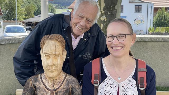 Jean Winiger et Anne Philipona, à côté de la sculpture de l'abbé Bovet à Sâles [RTSreligion - Carole Pirker]