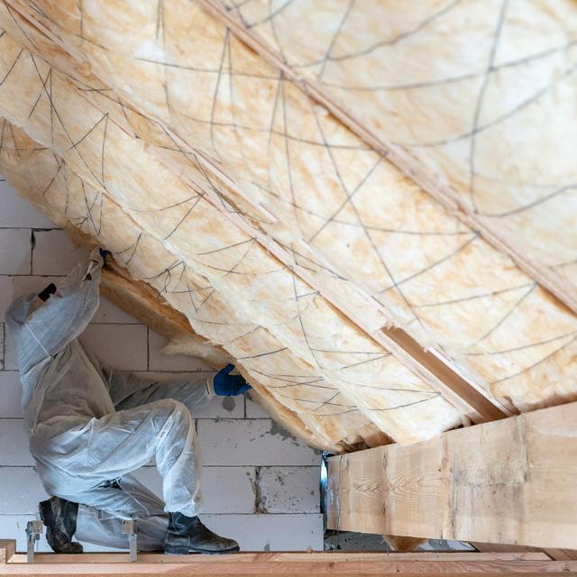 Un ouvrier travaillant sur l'isolation d'un bâtiment avec un matériau en laine de roche. [Depositphotos - brizmaker]