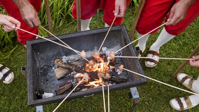 Des personnes font griller des cervelas lors de la Fête nationale le 1er août 2017 à Yvorne (VD) [KEYSTONE - JEAN-CHRISTOPHE BOTT]