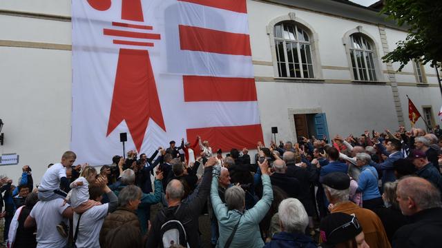 La conseillère fédérale Elisabeth Baume-Schneider et la présidente du Gouvernement jurassien Rosalie Beuret Siess entonnent la Rauracienne avec la population à Delémont le 23 juin 2024. [RTS - Gaël Klein]