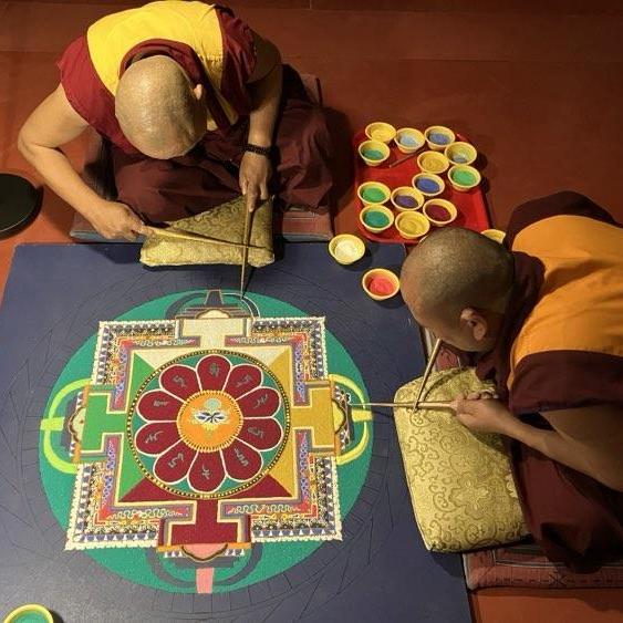 Deux moines bouddhistes réalisent un grand mandala en sables colorés [RTSreligion - Laurence Villoz]