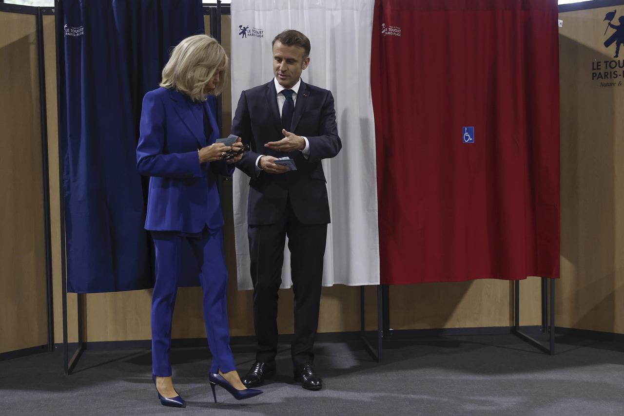 Le président français et son épouse Brigitte votent pour le second tour des élections législatives au Touquet (Pas-de-Calais) le 7 juillet 2024. [KEYSTONE - MOHAMMED BADRA]