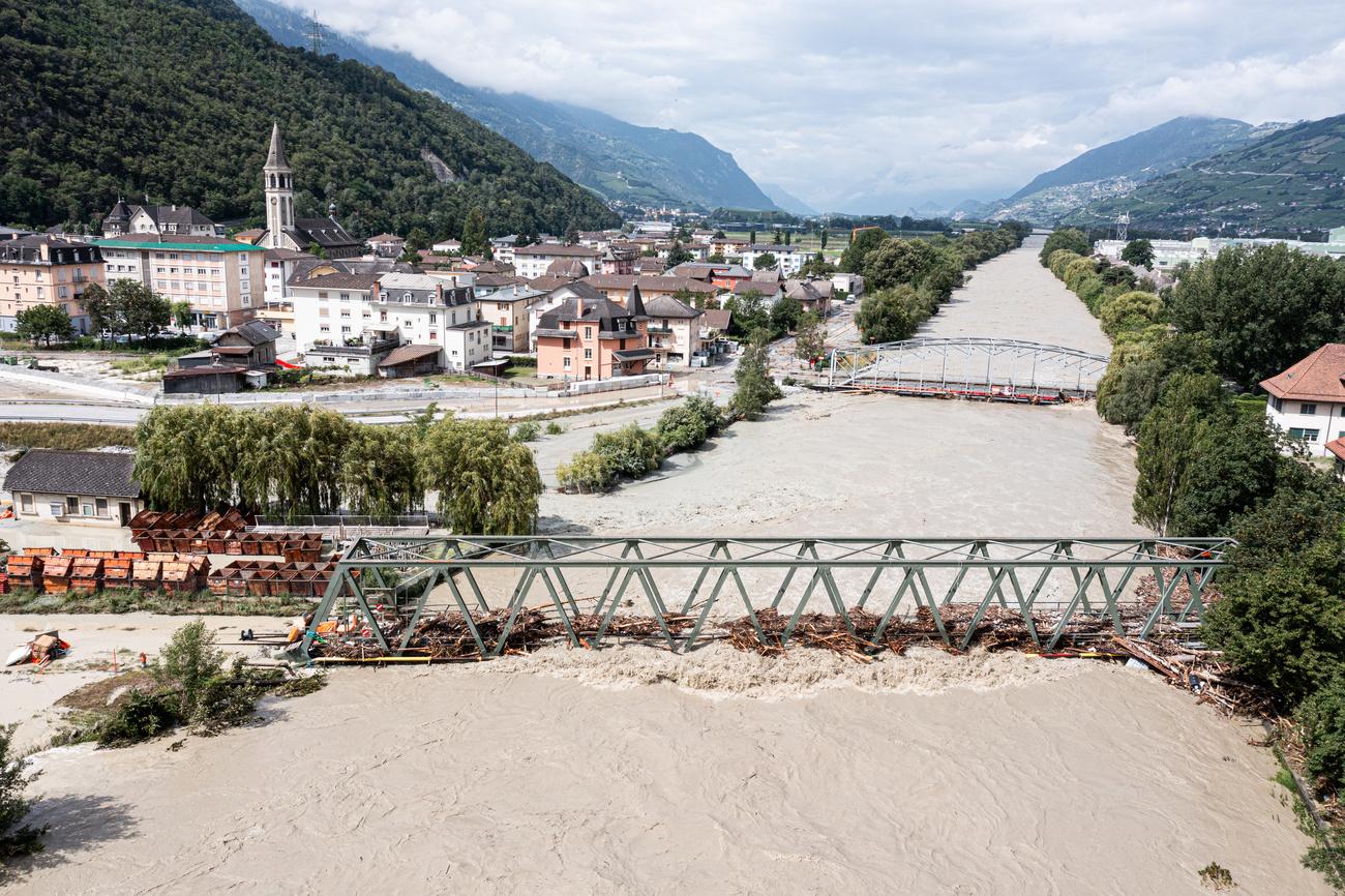 Des amas de bois pris dans un pont sur le Rhône à Sierre, le 30 juin 2024. [KEYSTONE - OLIVIER MAIRE]