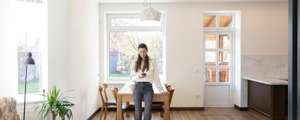 Une femme se tient dans un salon minimaliste. [Depositphotos - 4masik]