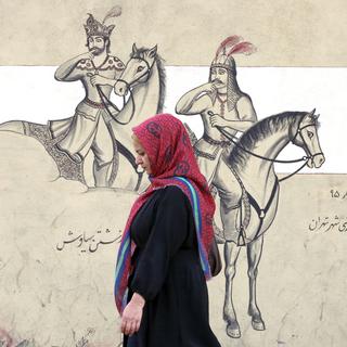 Une femme voilée passe devant une peinture murale à Téhéran le 10 octobre 2022. [EPA - Abedin Taherkenareh]