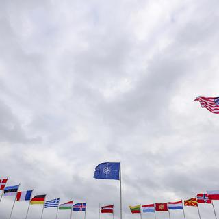 Les drapeaux des pays membres de l'OTAN flottent au vent devant le siège de l'OTAN à Bruxelles, le mardi 22 février 2022. [AP Photo - Olivier Matthys]