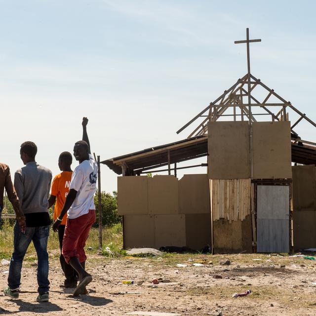 Des migrants devant une église de fortune à Calais.