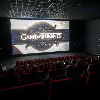 Des spectateurs regardent sur grand écran le dernier épisode de la huitième et dernière saison de la série Game of Thrones dans l'une des salles du cinéma Pathé Balexert, ce lundi 20 mai 2019 à Genève.