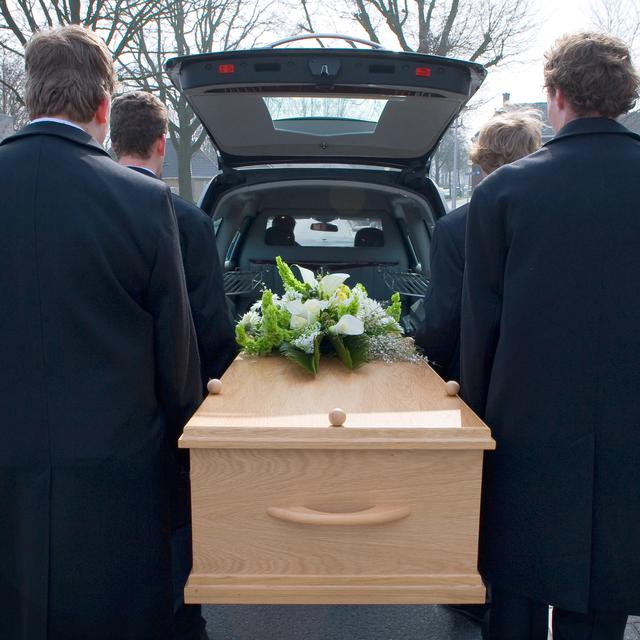Le cercueil est porté jusqu'au corbillard.