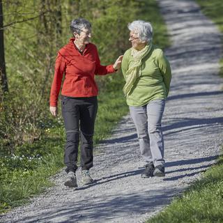 Deux femmes retraitées se promènent au soleil.