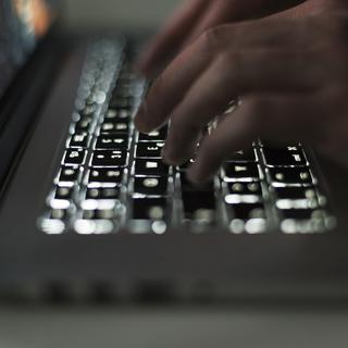 Un individu utilise un ordinateur portable avec un clavier lumineux, à Zurich, en Suisse, le 5 mars 2019.