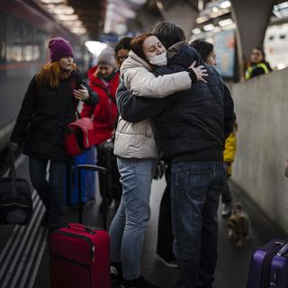 Une femme originaire d'Ukraine réagit alors qu'elle reçoit une accolade après son arrivée avec sa mère à la gare centrale de Zurich, suite à l'invasion de l'Ukraine par la Russie, à Zurich, en Suisse, le 9 mars 2022.