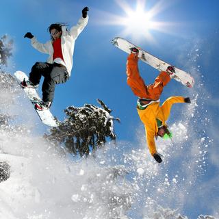 Snowboarder sautant contre le ciel bleu.