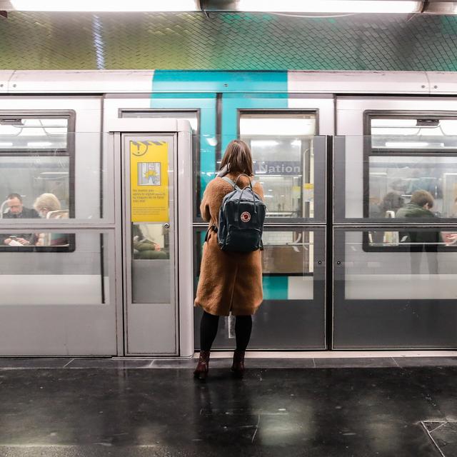 Une femme devant le métro parisien lors d'une perturbation des services ferroviaires, images d'illustration.