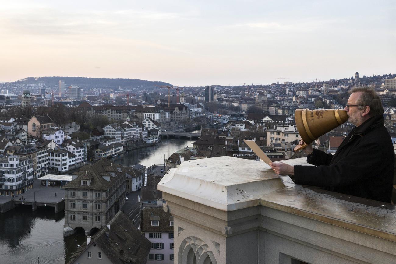 Le pasteur Christoph Sigrist donne la bénédiction depuis l'une des tours du Grossmuenster à Zurich. [Keystone - Ennio Leanza]